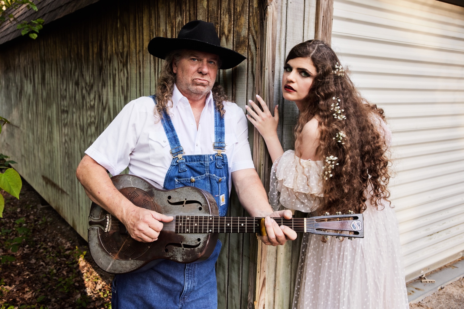 Nettie and the Delta Boy with resonator guitar by a shed